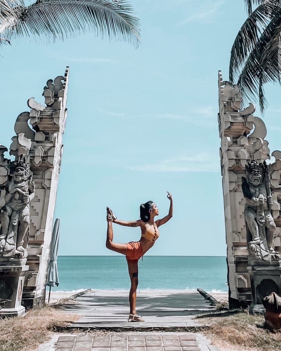 Nicha in dancer's pose between carved temple gates opening to the sea
